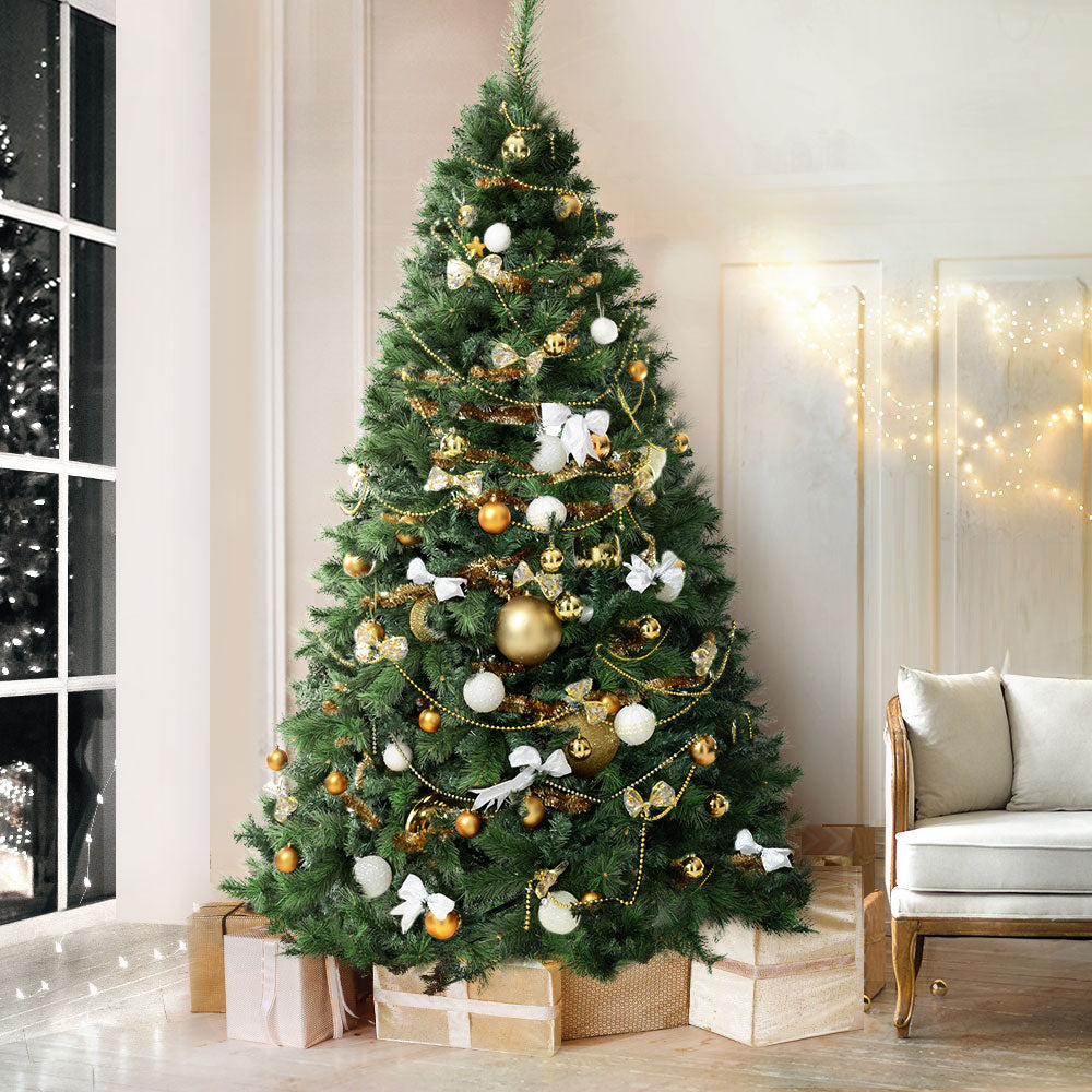 Translation missing: en.Fully decorated traditional Christmas tree with gold and white ornaments in a modern living room setting: Traditional Christmas Trees