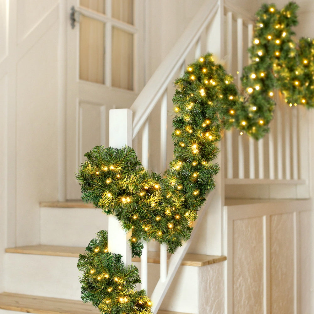 Translation missing: en.Pre-lit Christmas garland with warm white LED lights wrapped around a staircase railing: Garlands